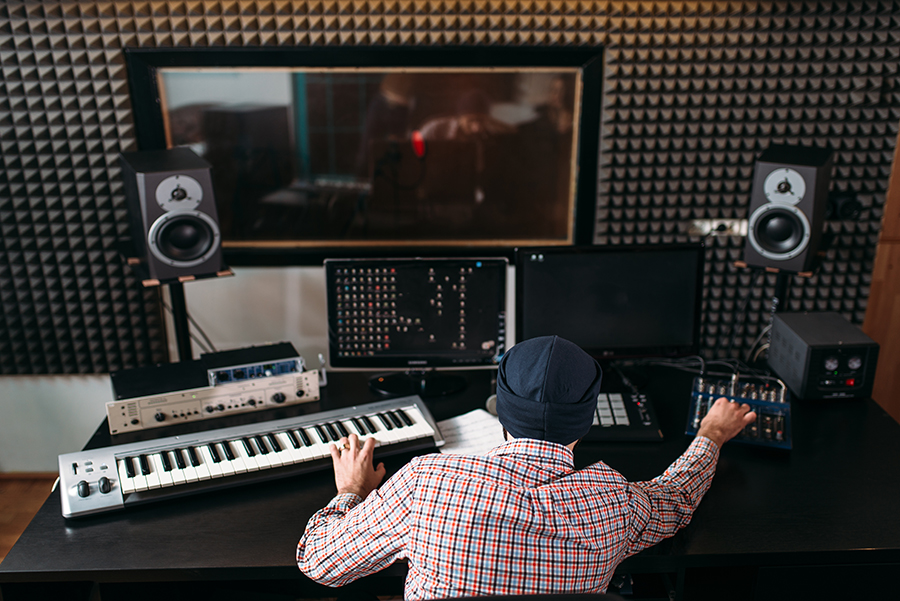 Il produttore del suono lavora con apparecchiature audio in studio.Tecnologia dei media digitali